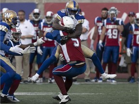 Winnipeg Blue Bombers's Anthony Gaitor (23) brings down Montreal Alouettes quarterback Drew Willy (5) for a sack, during second quarter action during CFL game at Molson Stadium on Friday June 22, 2018.