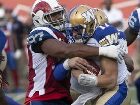 Alouettes' Eugene Lewis tackles Blue Bombers quarterback Chris Streveler during first-half action at Molson Stadium Friday night.