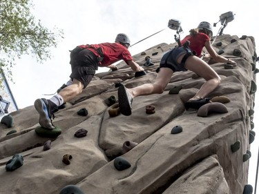 Antoine Beaudoin and Romane Carreau, both 15 years old, race each other to the top of a climbing wall set up by the climbing school Passe-Montagne during  Fête nationale activities on St-Denis St. in Montreal on Sunday, June 24, 2018.