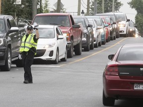 Police officer Pasqual Spagnuolo directs traffic at the corner of Clément St. and the on-rap for the 138, as cars try to make it to the Mercier Bridge on June 28, 2018.