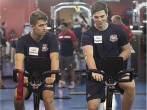 Canadiens prospects Cole Fonstad and Cale Fleury ride stationary bikes during off-ice testing on the first day of evaluation camp at the Bell Sports Complex in Brossard on June 28, 2018.