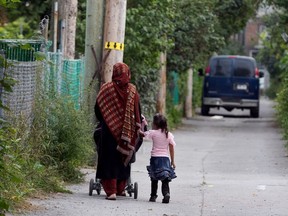 A woman and child walk through a Montreal alleyway.