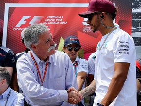 Chase Carey, CEO of the Formula One Group, shakes hands with Lewis Hamilton of Britain before the Canadian Grand Prix at Circuit Gilles Villeneuve on June 11, 2017, in Montreal.