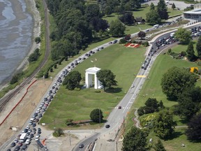 In this July 24, 2009, file photo, cars line-up heading into the United States at left and into Canada at right adjacent to Boundary Bay at a border crossing at Blaine, Wash.