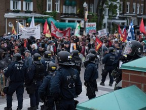 Protestors march before riot police during an anti-G7 demonstration in Quebec City, Quebec, June 7, 2018, on the eve of the leaders' summit.