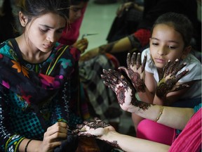 A Pakistani beautician applies henna designs to a customer at a beauty salon ahead of the Eid al-Fitr holiday which marks the end of the holy month of Ramadan, in Karachi on June 13, 2018. Muslims around the world are preparing to celebrate the Eid al-Fitr holiday, which marks the end of the fasting month of Ramadan.