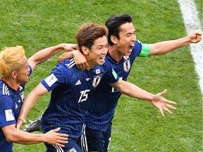Japan's forward Yuya Osako (C) celebrates with Japan's defender Yuto Nagatomo (L) and Japan's midfielder Makoto Hasebe after scoring their second goal during the Russia 2018 World Cup Group H football match between Colombia and Japan at the Mordovia Arena in Saransk on June 19, 2018.