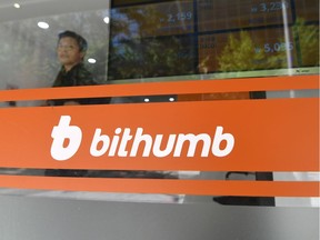 A man glances through a window at Bithumb virtual currency exchange in Seoul on June 20, 2018. Hackers stole more than 30 million USD worth of cryptocurrencies from South Korea's top bitcoin exchange, sending the unit's price falling around the world on June 20.