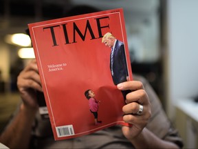 An AFP journalist reads a copy of Time Magazine with a front cover using a combination of pictures showing a crying child taken at the U.S. border with Mexico and a picture of U.S. President Donald Trump looking down, on June 22, 2018, in Washington, D.C.