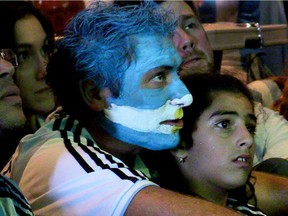Argentinian fans Mauricio Di Francesco and his step daughter Zeineb Daoud watch the World Cup semi final game against the Dutch at the Club Espagnol de Québec in Montreal on July 9, 2014.