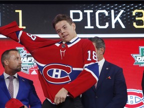 Jesperi Kotkaniemi, of Finland, dons a Montreal Canadiens jersey after being chosen by the team during the NHL hockey draft in Dallas, Friday, June 22, 2018.