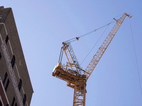 A construction crane is seen in Montreal on October 12, 2017. Crane operators were back at Quebec construction sites today after more than a week off the job. The operators were protesting changes made to training requirements last May that will allow workers to operate cranes without first obtaining a vocational diploma. The union says the new training program is less comprehensive and could lead to a rise in workplace accidents.