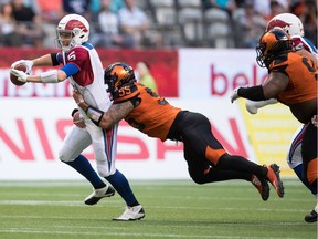 Montreal Alouettes quarterback Drew Willy, left, is sacked by B.C. Lions' Gabriel Knapton during the first half of a CFL football game in Vancouver, on Saturday June 16, 2018.