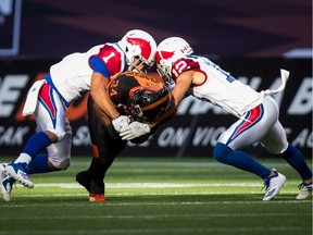 Alouettes' Branden Dozier (1) and Mitchell White tackle Lions' Jeremiah Johnson during first half last week in B.C.