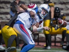 Alouettes quarterback Garrett Fugate fumbles the ball as he is sacked by Hamilton Tiger-Cats defensive back Jackson Bennett during second half preseason CFL football action in Montreal on Saturday, June 9, 2018.
