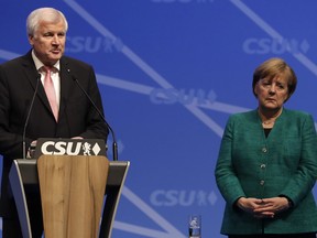 In this Dec. 15, 2017 photo German Chancellor and chairwoman of the Christian Democratic Union (CDU) party, Angela Merkel, stands besides Bavarian State Governor and Chairman of German Christian Social Union party, CSU, Horst Seehofer.