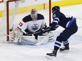 Edmonton Oilers goaltender Cam Talbot makes save on Winnipeg Jets' Joel Aria during game on Dec. 27, 2017.