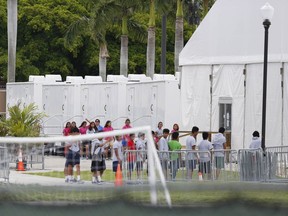 Immigrant children walk outside the Homestead Temporary Shelter for Unaccompanied Children a former Job Corps site that now houses them, on Wednesday, June 20, 2018, in Homestead, Fla. U.S. Rep. Carlos Curbelo said he found it "troubling" to see two of his Democratic colleagues turned away from the Miami-area detention center for migrant children.