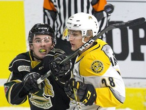 London Knight Liam Foudy reaches the puck while being tangled up by Kelton Hatcher of the the Sarnia Sting in London, Ont. on Monday January 1, 2018.
