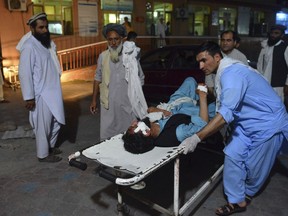 A wounded man is brought by stretcher into a hospital in Jalalabad city, capital of Nangarhar province, east of Kabul, Afghanistan, Saturday, June 16, 2018.