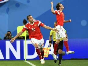 Russia's Artyom Dzyuba, left, celebrates with Russia's Mario Fernandes, right, after scoring his side's third goal during the group A match between Russia and Egypt at the 2018 soccer World Cup in the St. Petersburg stadium in St. Petersburg, Russia, Tuesday, June 19, 2018.