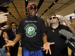 Former NBA basketball player Dennis Rodman, and Chris Volo, right, arrive at Singapore's Changi Airport June 12, 2018.
