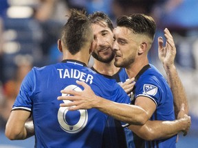Montreal Impact's Alejandro Silva, right, celebrates with teammates Ignacio Piatti, centre, and Saphir Taider after scoring against Sporting Kansas City during second half MLS soccer action in Montreal, Saturday, June 30, 2018.
