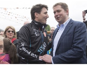 Prime Minister Justin Trudeau, left, shakes hand with Conservative Leader Andrew Scheer at the start of the Defi Pierre Lavoie, a 1000km bicycle trek, Thursday, June 14, 2018 in Saguenay Que.THE CANADIAN PRESS/Jacques Boissinot ORG XMIT: JQB106