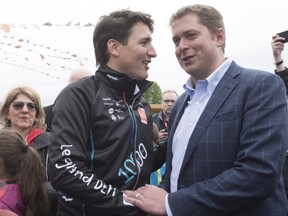 Prime Minister Justin Trudeau, left, shakes hand with Conservative Leader Andrew Scheer at the start of the Defi Pierre Lavoie, a 1000km bicycle trek, Thursday, June 14, 2018 in Saguenay Que.