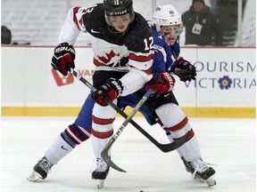 Team USA defenceman Scott Perunovich defends against Canada forward Boris Katchouk (12) during a preliminary round game of the IIHF World Junior Championship in Orchard Park, N.Y., on Dec. 29, 2017.