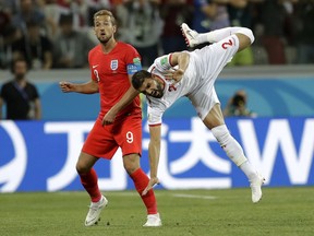 Tunisia's Syam Ben Youssef, right, jumps as he fights for the ball with England's Harry Kane during the group G match between Tunisia and England at the 2018 soccer World Cup in the Volgograd Arena in Volgograd, Russia, Monday, June 18, 2018.