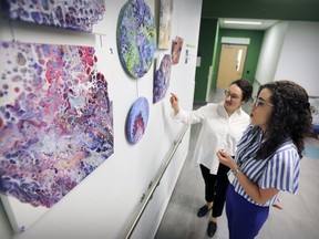 Alexandra Kirsh, left, curator of the RBC Art and Heritage Centre of the MUHC, looks at the Glen site's latest exhibition of works by cancer patients participating in an art therapy program run by Cedars CanSupport with art therapist Katelyn Brinkman.