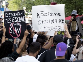 Protestors listen to speeches as they gather outside of the SLĀV show at the Théâtre du nouveau monde in Montreal in June.