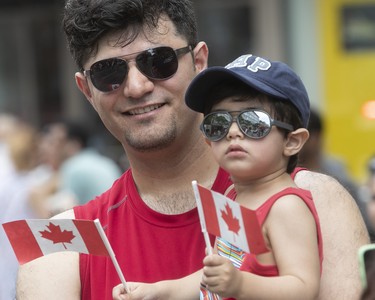 Ehsan Saboori and his two year-old son Artin enjoy the Canada Day parade in downtown Montreal on Sunday July 1, 2018. (Pierre Obendrauf / MONTREAL GAZETTE)