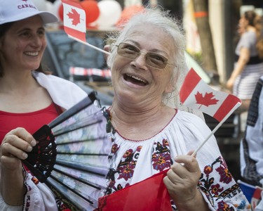 Elena Stan uses a paper fan to try and keep cool, as she participates in the Canada Day parade in Montreal on Sunday July 1, 2018. (Pierre Obendrauf / MONTREAL GAZETTE)