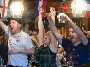 Ollie Kavanagh, left, with his wife, Kat, and friend Jeremy O'Brien celebrate England's final goal at Bishop & Bagg Pub in Mile End on Tuesday July 3, 2018.