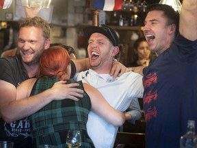 No doubt who they are rooting for: James Roberts, far left, Ollie Kavanagh, centre, with his wife, Kat, and friend Jeremy O'Brien, far right, celebrate England's victory over Colombia at pub in Mile End  on Tuesday, July 3, 2018.