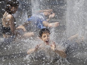 MONTREAL, QUE.: JULY 3, 2018-- Zachary DeGuire of Philadelphia joins other kids as they play in the water jets at the Montreal International Jazz festival as Montreal endures a heat wave on Tuesday July 3, 2018. (Allen McInnis / MONTREAL GAZETTE) ORG XMIT: 60989