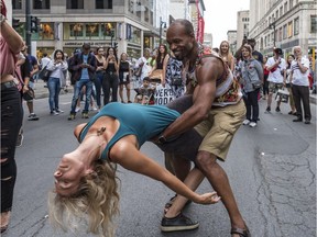 Boyfriend/girlfriend Branka Zoric & Marc Rosario Joseph dance up a storm to the sounds of latin music playing at the annual Ste-Catherine Street sidewalk sale at Peel St. on Friday, July 13, 2018. The sale continues until Sunday.