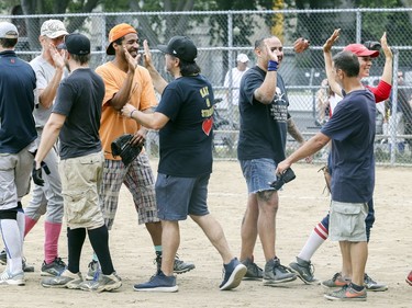Players exchange high-fives following exhibition softball game between local players and Expos Nation at Jeanne Mance Park in Montreal Saturday July 14, 2018.  The event was held in response to the Plateau Mont-Royal's decision to close the north softball field in the same park.  The local players defeated Expos Nation 12-7.  (John Mahoney / MONTREAL GAZETTE) ORG XMIT: 61056 - 0626