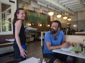 Server Jennifer Morzier shares a laugh with customer Vincent Lessard at the vegan restaurant Aux Vivres in Westmount on Thursday, July 19, 2018.