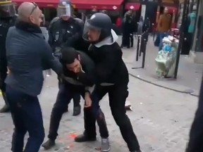 In this image taken from video, a man identified as Alexandre Benalla, right, a security chief to French President Emmanuel Macron, confronting a student during a May Day demonstration in Paris, May 1, 2018. The video came to light Thursday July 19, 2018, showing one of Macron's security chiefs beating a student demonstrator,