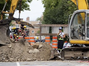 An Énergir gas work crew monitors the site after a work crew installing a new sewer to a residential building under renovation punctured a natural gas line on Girouard Ave. just north of Monkland Ave. on Monday.