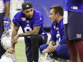 Alouettes newly-acquired quarterback Johnny Manziel, right, speaks with fellow quarterback Vernon Adams during his first practise with the team on Monday. Adams is expected to start on Thursday vs. the Eskimos.