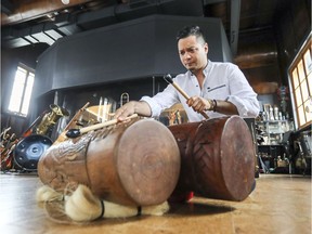 Musician/composer Brian D'Oliveira plays a teponaztli in the La Hacienda Creative studio Tuesday, July 24, 2018.