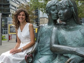 Joanna Abrahamowicz, a guide at the McCord Museum, sits next to the Secret Bench, a bronze sculpture by Lea Vivot on the west side of McGill College Ave.