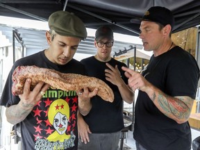 Celebrity chef Danny Smiles smells the rub on a brisket as he and Chuck Hughes, right, check in with barbecue pitmaster Dylan Kier of Blackstrap BBQ. They are getting ready to cater at the Osheaga and Heavy Montteal music festivals.