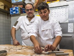 Making cannoli is a family affair at San Pietro bakery, where Leo Calderone watches over 13-year-old son Pietro as he forms a shell.