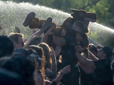 A heavy metal fan dressed in a moose outfit is taken from the crowd after crowd surfing during a set by Trivium during the Heavy Montreal Festival on Sunday, July 29, 2018.