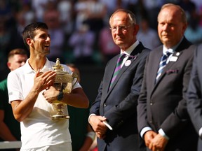 Novak Djokovic of Serbia celebrates with the trophy after winning the Men's Singles final against Kevin Anderson of South Africa on day thirteen of the Wimbledon Lawn Tennis Championships on July 15, 2018 in London, England.